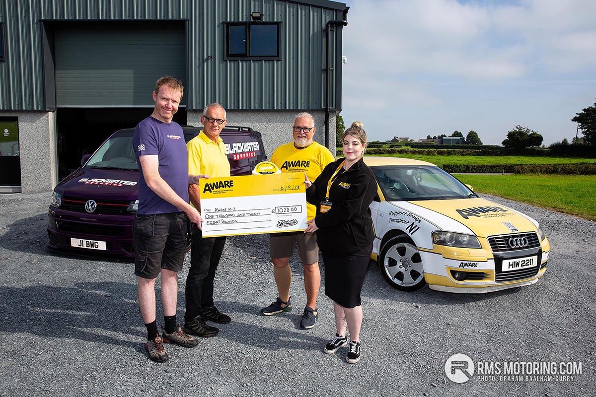 Andrew Johnston of Blackwater Graphics in Ballygowan presents a cheque for £1,028 to Jarlath McCreanor, Klaus Viesteg and Shannon Shivers from Aware NI.(S3)